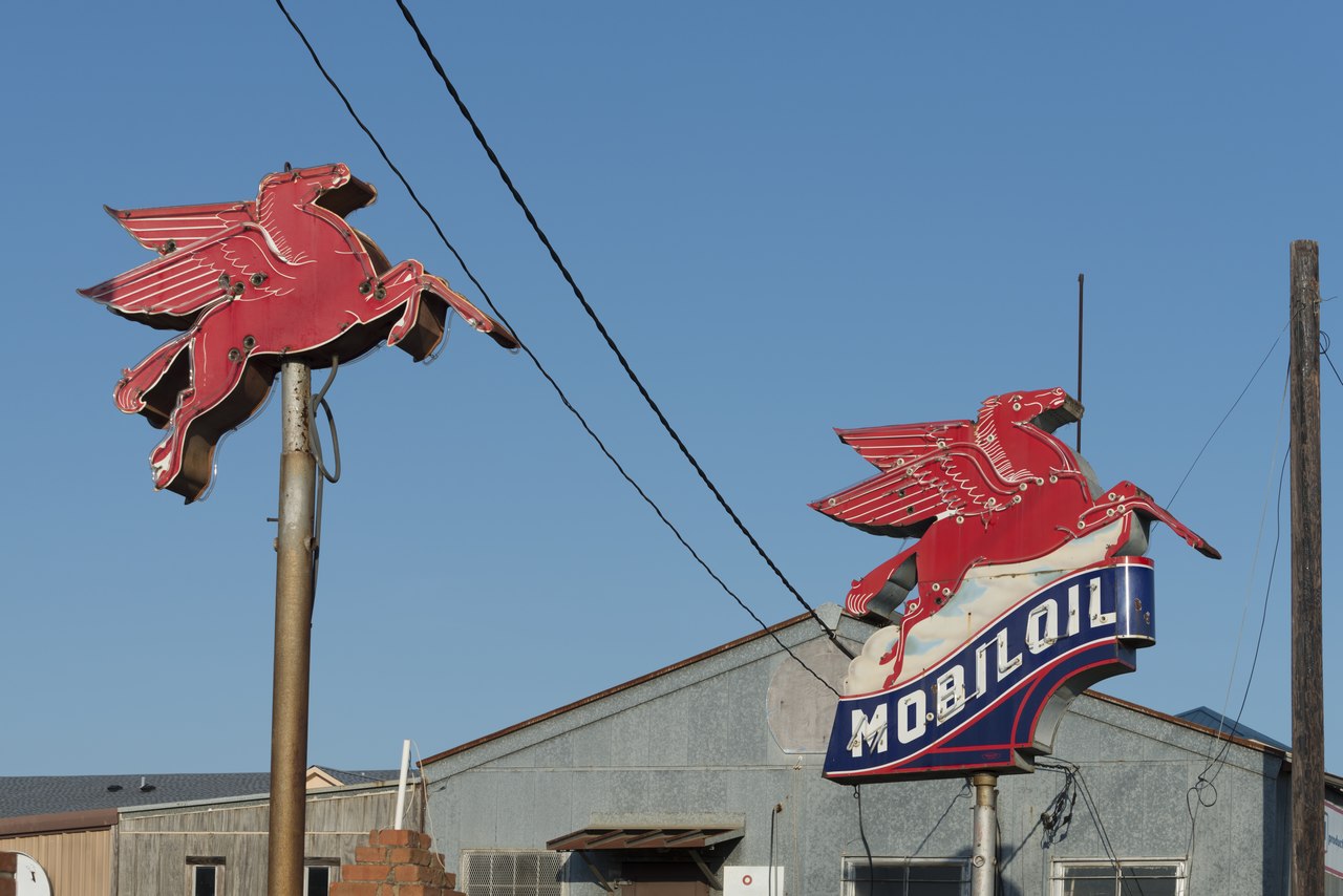 Side-by-side vintage Mobil pegasus (flying horse) gas station insigias along a road in East Texas