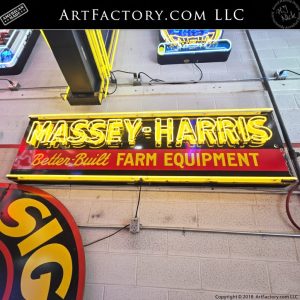 Vintage Massey-Harris neon sign, antique farm equipment advertising, yellow neon porcelain sign on white brick wall, Massey-Harris Better-Built Farm Equipment collectible.